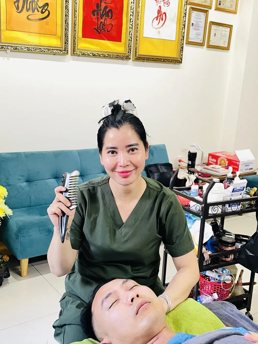 Lương Y Trần Thị Hồng Xuân tại Cơ sở Chăm Sóc Sức Khỏe Hồng Xuân, đang giải cơ bằng lược sừng cho khách